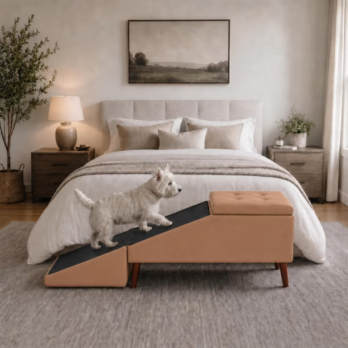 A staged bedroom scene with a bed dressed in white bedding, a tan upholstered bench at the foot, a small corgi lying on the bed, and neutral wall decor and bedside lamps camel