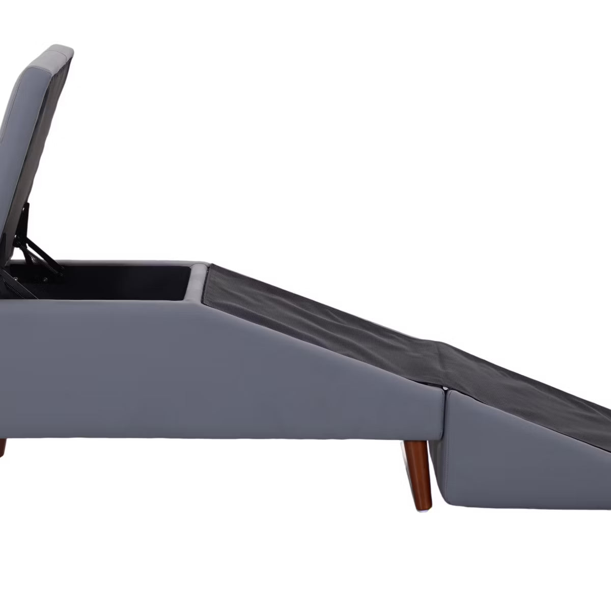 A small white dog stands on a gray pet ramp positioned in front of a bed in a softly styled bedroom. The ramp has a dark gray textured surface and a matching gray tufted rectangular end, with wooden legs.