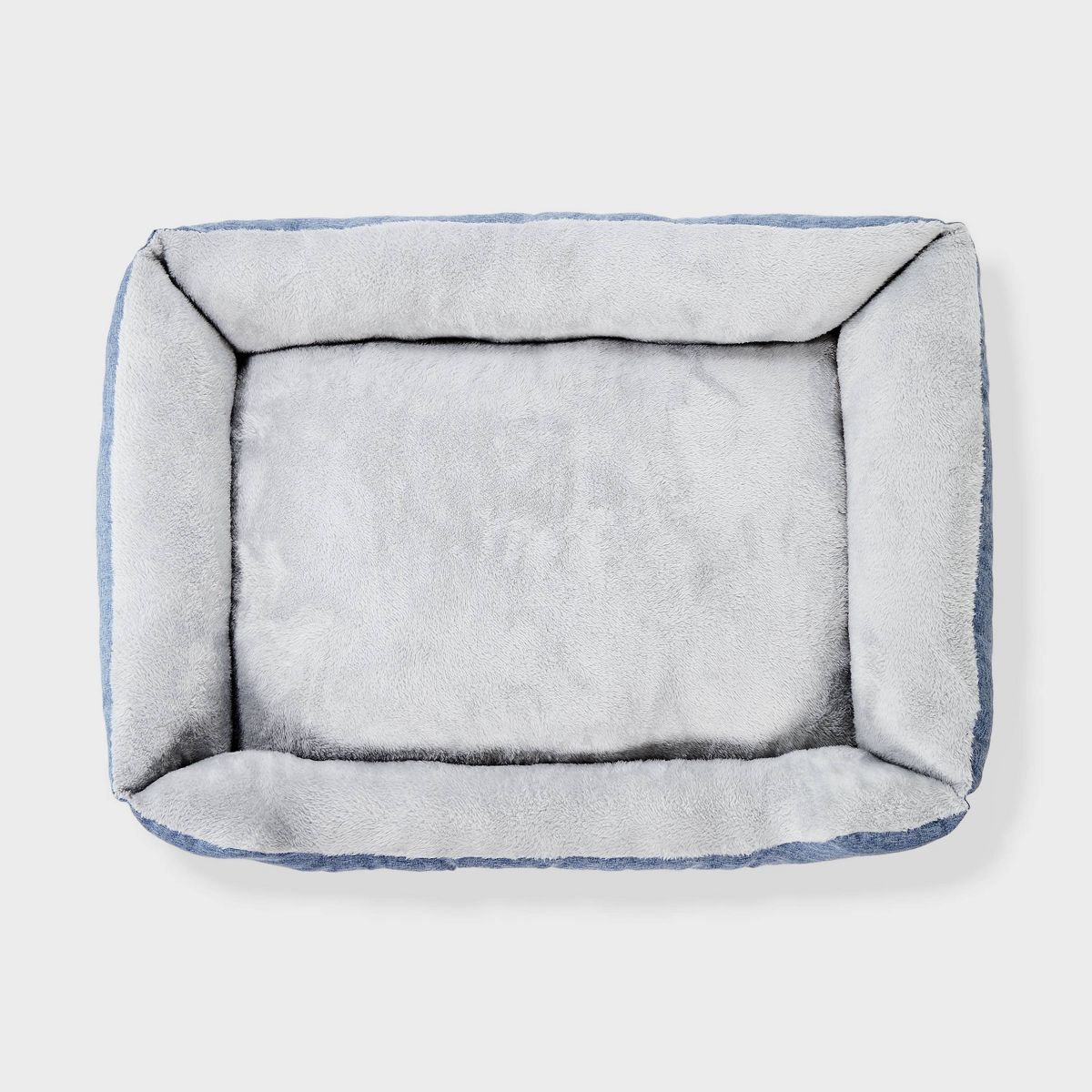Gray pet bed with white interior on a light gray background