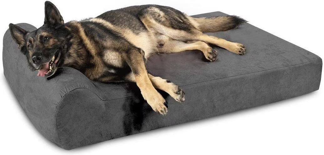 A German Shepherd dog lies stretched out on a dark gray rectangular pet bed against a plain white background.